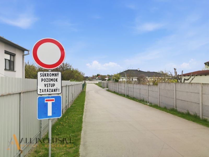The path between fences in Rohovce, marked with a no-entry sign. Properties - residential.