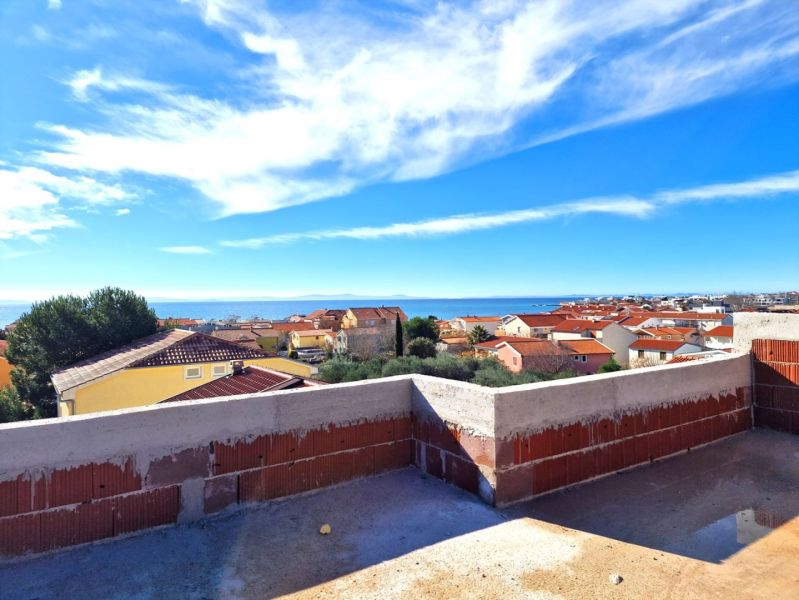 View from the terrace of a 3-room apartment in Privlaka to the sea and rooftops of houses.