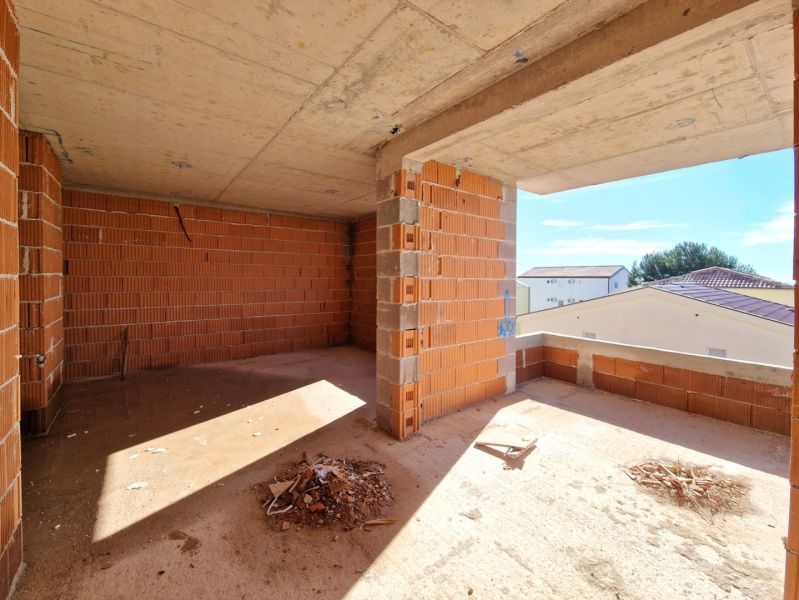 Unfinished room in a 3-room apartment with brick walls and a concrete ceiling.