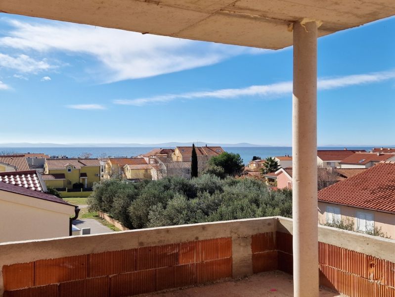 Sea view from a 3-bedroom apartment in the town of Privlaka, above the surrounding houses and trees.