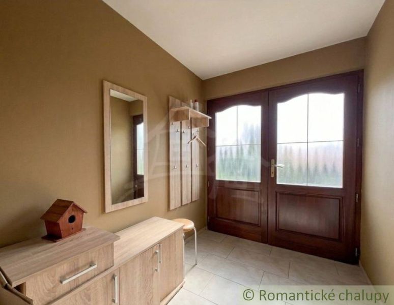 Entrance hall with wooden furniture and a mirror in a family house.