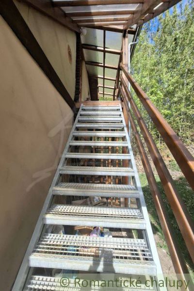 Exterior stairs leading to a family house in Cinobana with a green background.