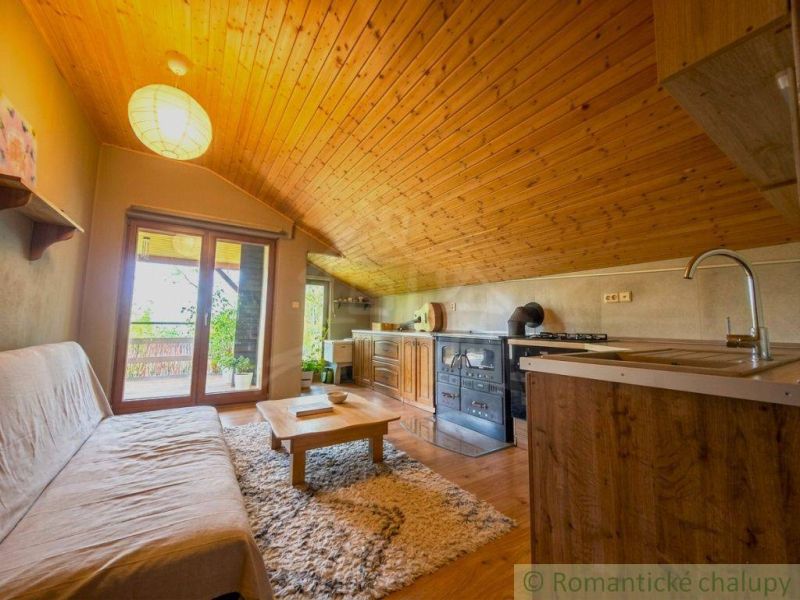 Attic space of a family house with a wooden ceiling, floor with wooden decor.