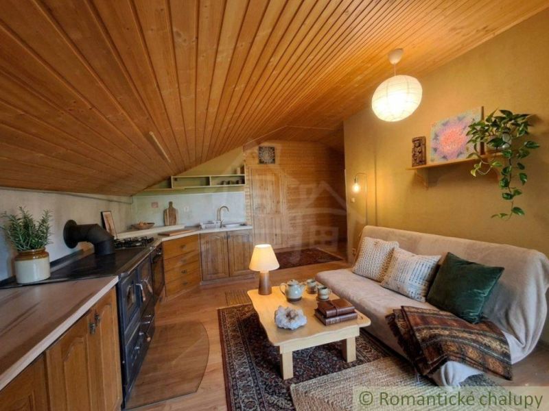 A kitchen corner with a traditional stove and a sofa in a family house with a wooden decor floor.