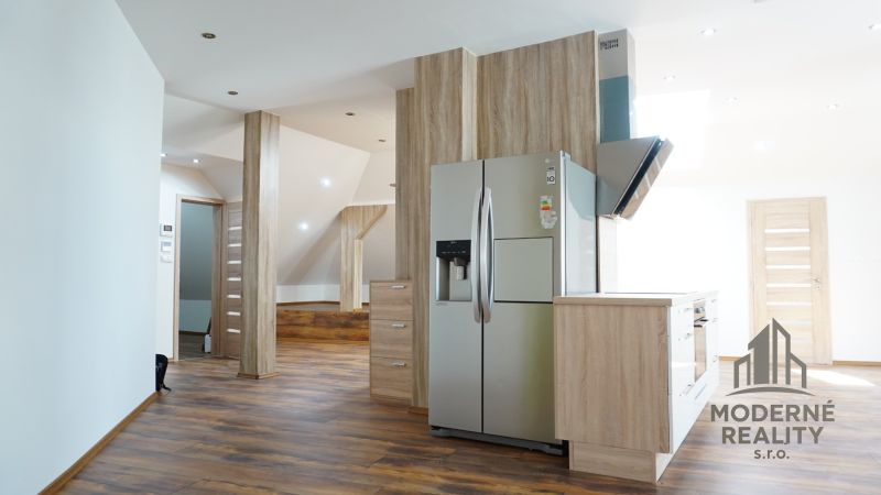A kitchen with built-in appliances and a wooden decor floor in a 4-room apartment.
