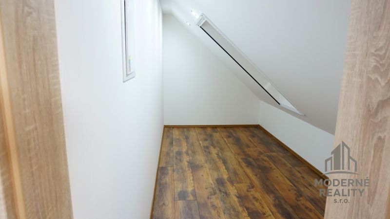 Attic room with a skylight and a wooden decor floor in a 4-room apartment.