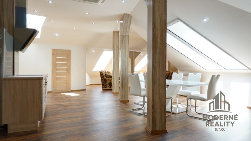 A bright interior of a 4-room apartment with a wooden decor floor and a dining table.