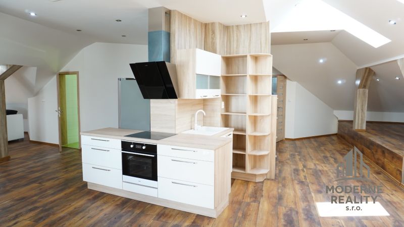 A kitchen in a 4-room apartment with built-in appliances and a wooden decor floor.