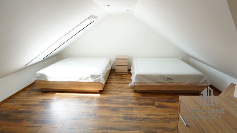 Attic room in a 4-room apartment with beds and a floor with a wooden decor.
