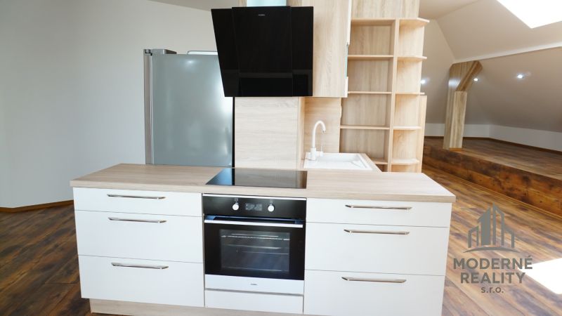 A kitchen in a 4-room apartment with a wood-patterned floor, built-in appliances, and storage spaces.
