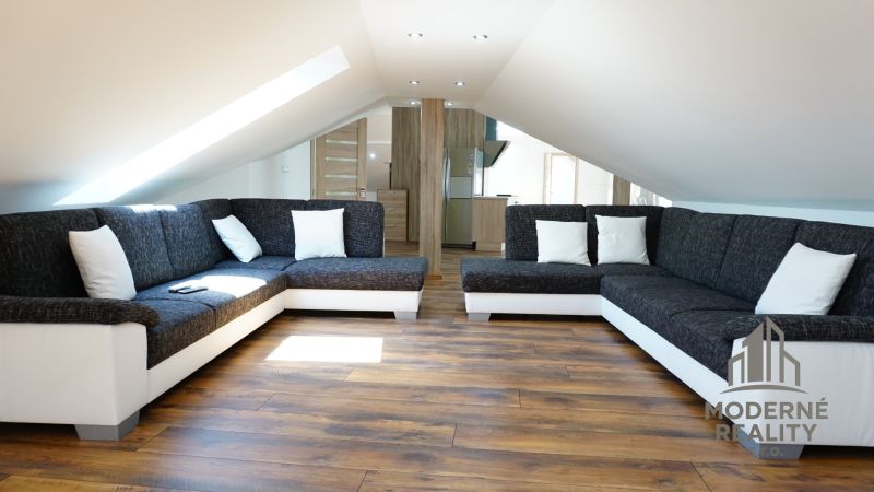 Attic living room in a 4-room apartment with sofas and a wooden decor floor.