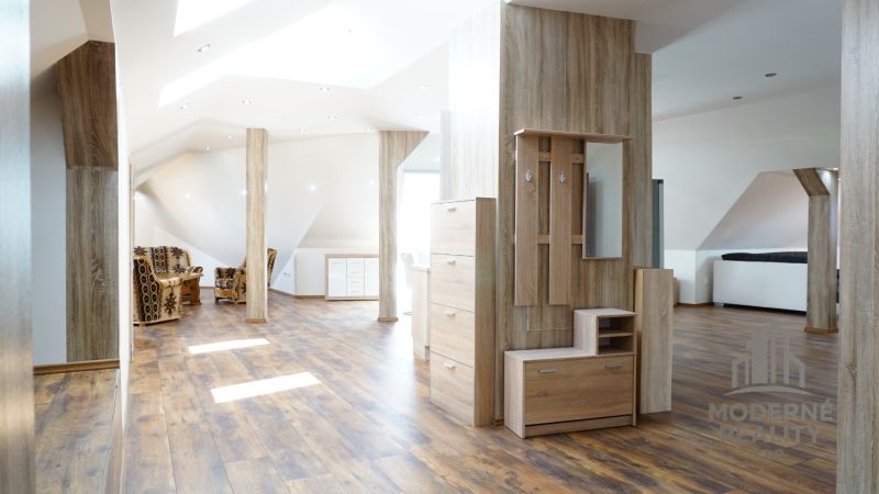 Attic interior of a 4-room apartment with a wooden decor floor and comfortable seating.