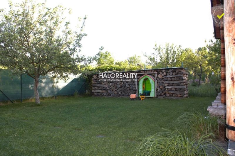 A garden near a cottage with a wooden shed in Piešťany surrounded by trees and a lawn.