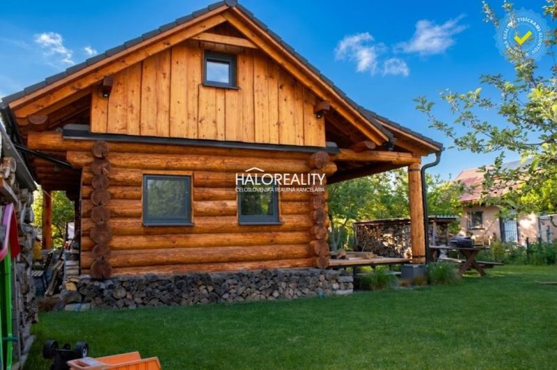 A wooden cottage in Piešťany surrounded by greenery with wood in stock.