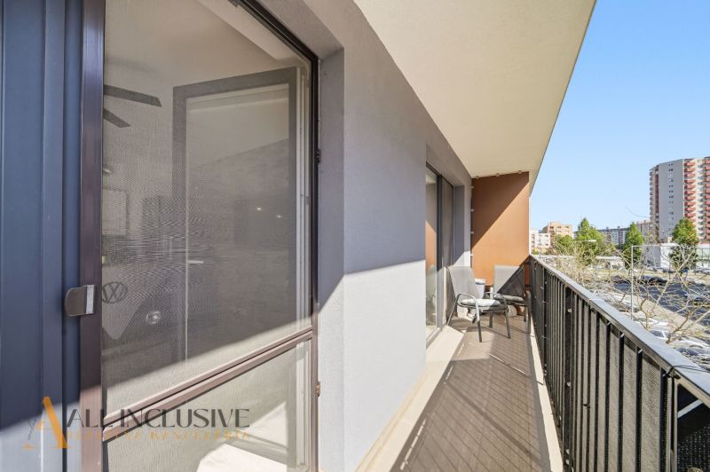 Balcony of a 2-room apartment on Zuzany Chalupovej with furniture and a sunshade, in the background Petržalka.