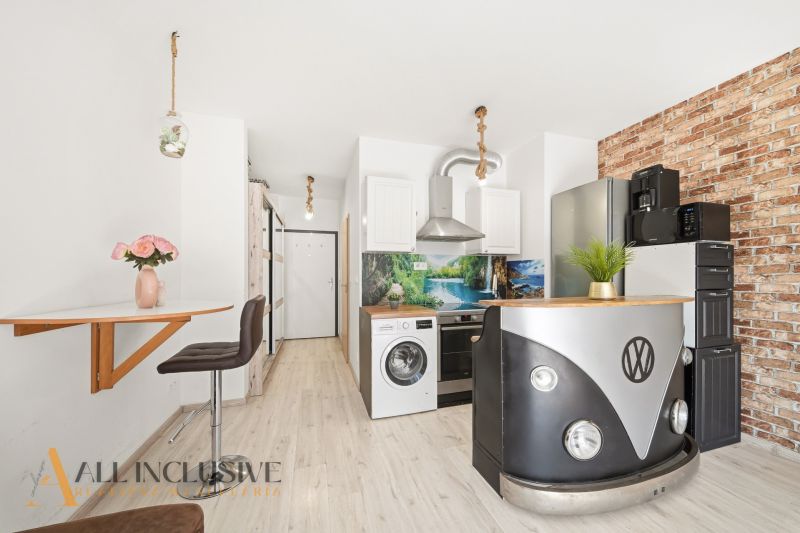 A kitchen with an original VW table and a floor with a wooden decor in a 2-room apartment.