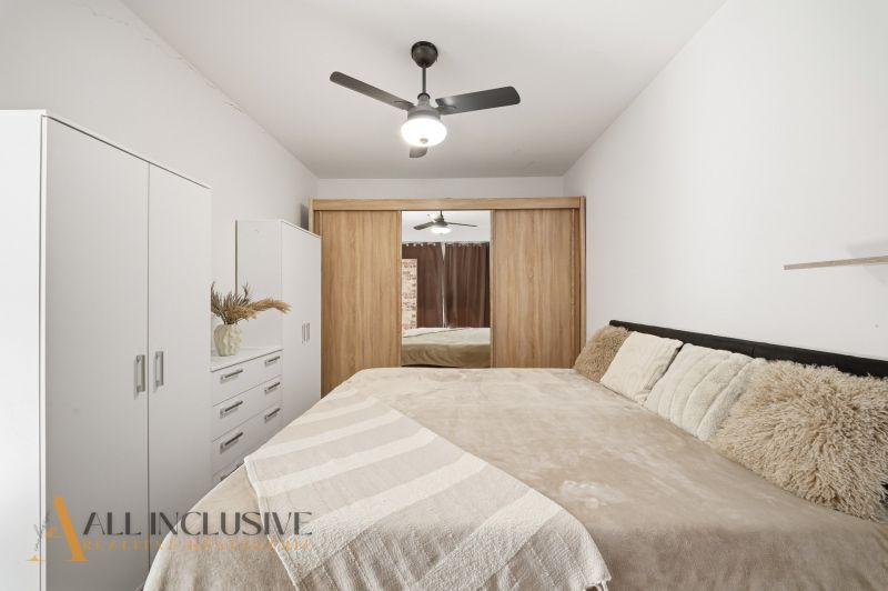 A bedroom with a large bed and a wardrobe in a 2-room apartment.