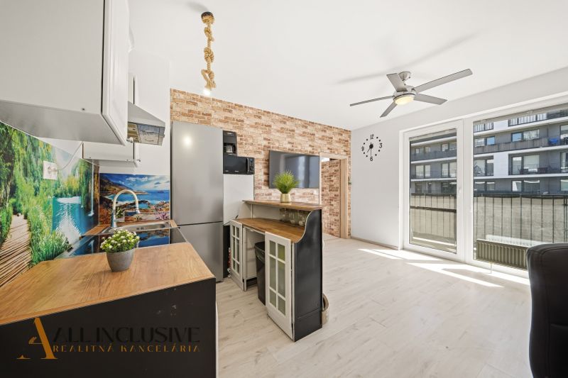 A kitchen with a bar counter and a wooden decor floor in a 2-room apartment.