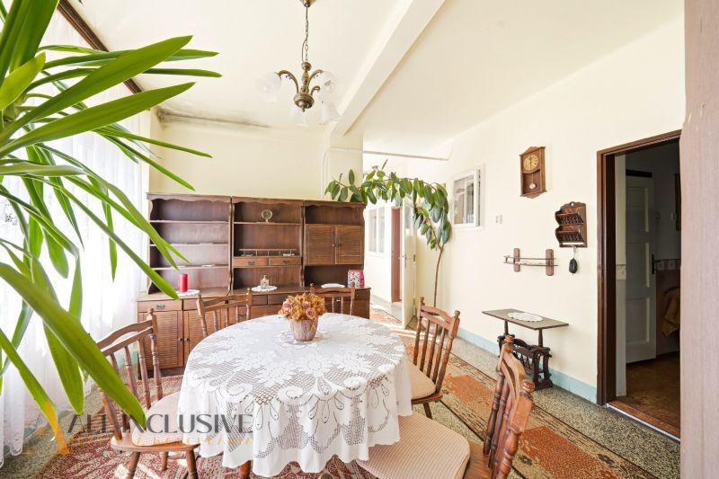 Dining room in a family house with a round table and wooden furniture.