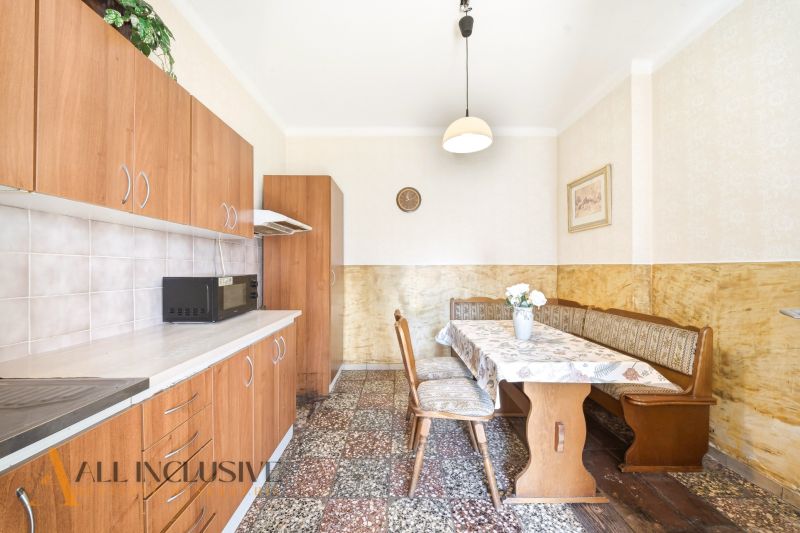A kitchen in a family house with a dining area and cabinets with a wooden decor.