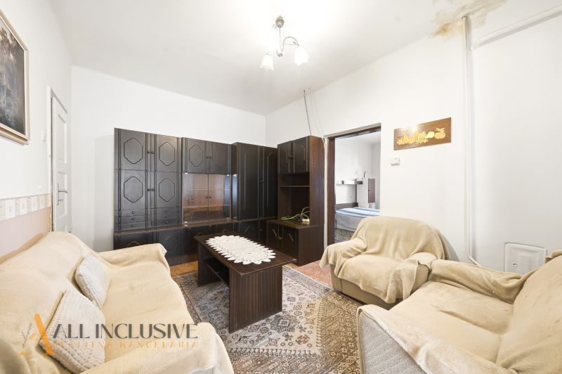 Living room with dark furniture and a floral carpet in a family house.