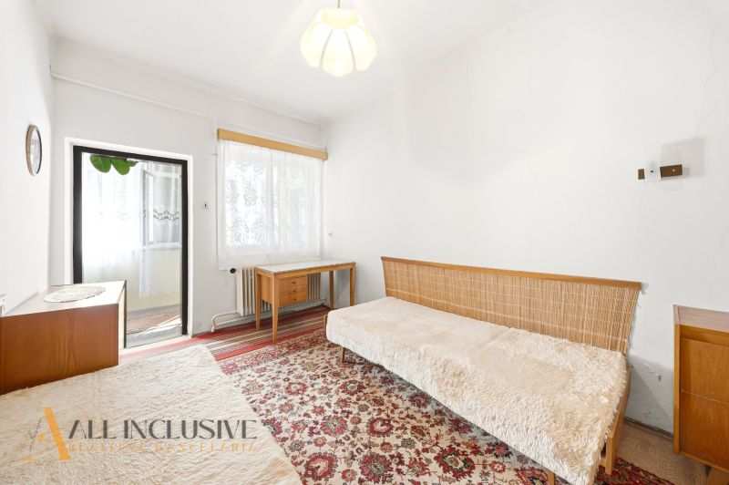 Interior of a family house with a carpet, sofa, table, and lamp.
