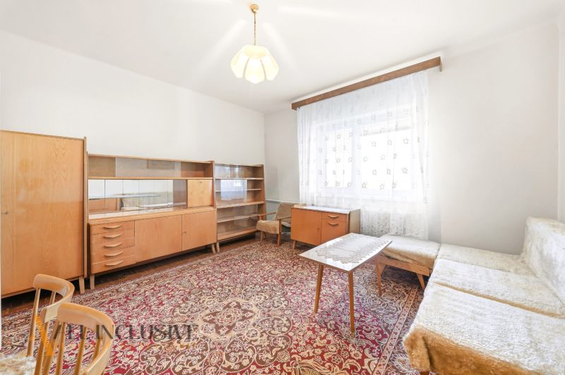 Living room in a family house with a carpet and wooden furniture.