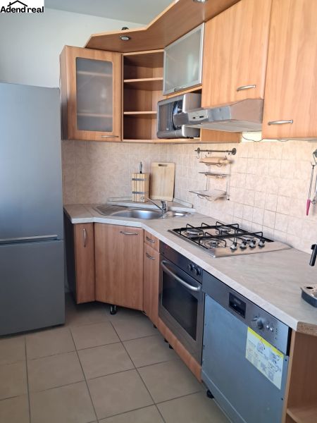 A kitchen in a 2-room apartment with a wooden decor and white appliances.
