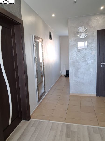 A hallway in a 2-room apartment with tiles, a mirror, and dark doors.