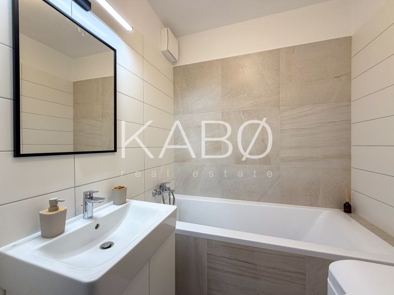 Elegant bathroom with a minimalist sink and bathtub in a 2-room apartment.