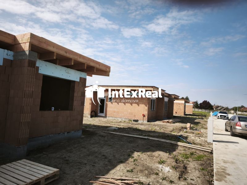 Construction of a family house on the street in Čierny Brod with cars in the parking lot.