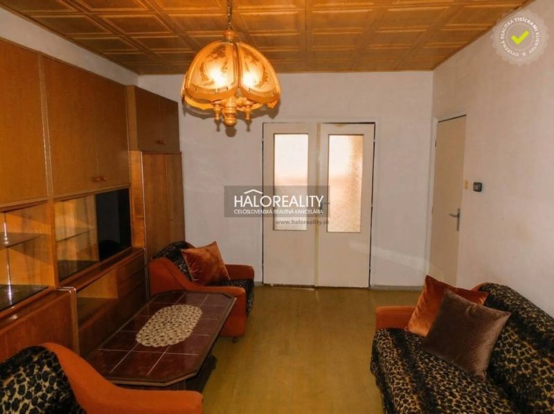 Living room in a 3-room apartment with a wooden decor floor and retro lighting.