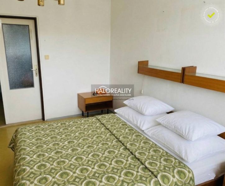 A bedroom with a double bed in a 3-room apartment, nightstand, white wall.