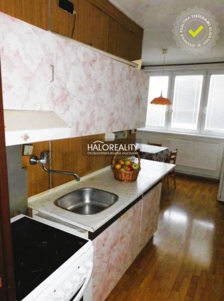 A kitchen with a built-in sink and a wooden decor floor in a 3-room apartment.