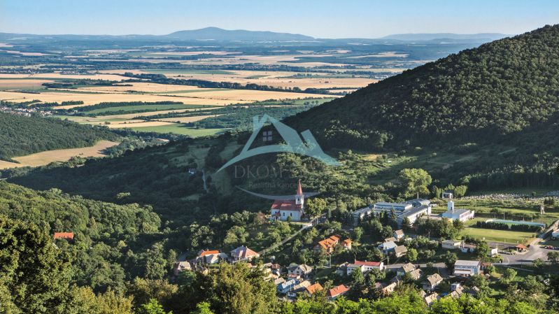 Panoramic view of a village in a valley, surrounded by forests and fields. Land suitable for living.