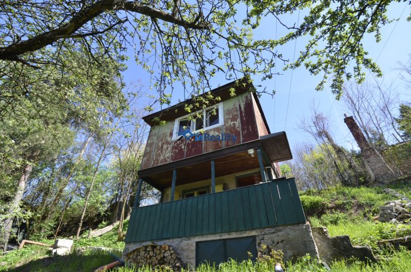 A cottage surrounded by greenery and trees in gardens around Zvolen.