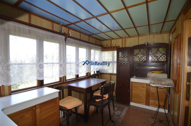Interior of a garden with a dining table and cabinets, sunny environment through the windows.