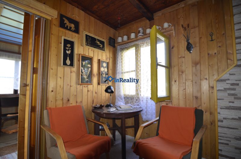 Wooden wall paneling in the Gardens with decorations and two chairs by the table.