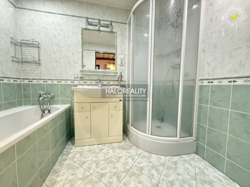A bathroom in a 3-room apartment with a bathtub, shower, and washbasin cabinet.