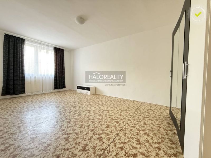 Bedroom in a 3-room apartment with carpet pattern flooring and dark curtains.