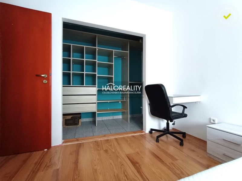 A room in a 2-room apartment with a wooden decor floor and a built-in wardrobe.