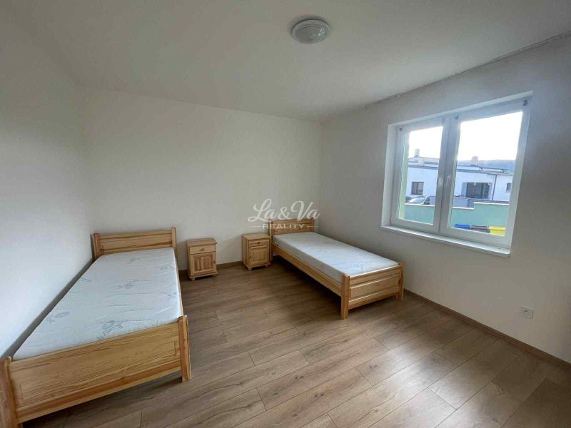 A room with two single beds, nightstands, and a floor with a wooden decor.