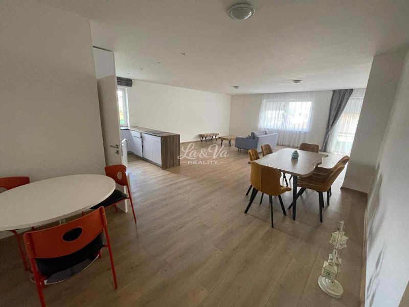 Spacious living room and dining area in a family house with wooden decor flooring.
