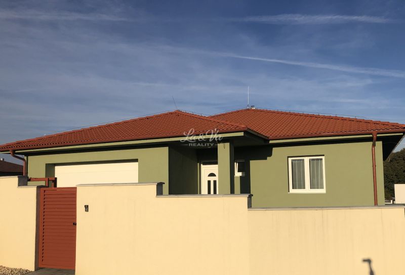 A family house in Kynko, Nitra with a green facade and a red roof.