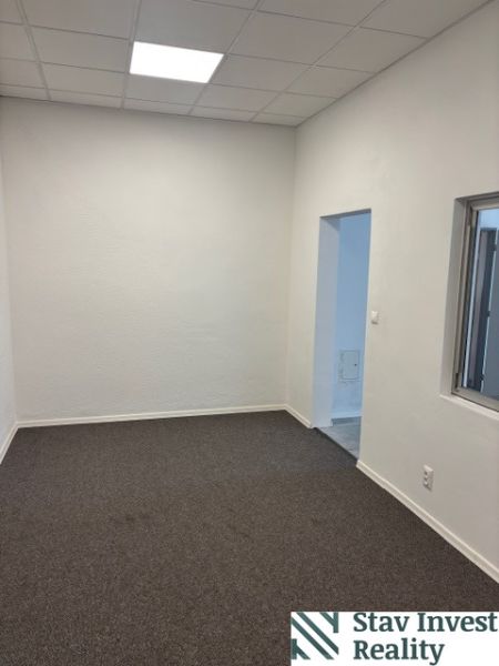 Offices with white walls and gray carpet, visible entrance doors.