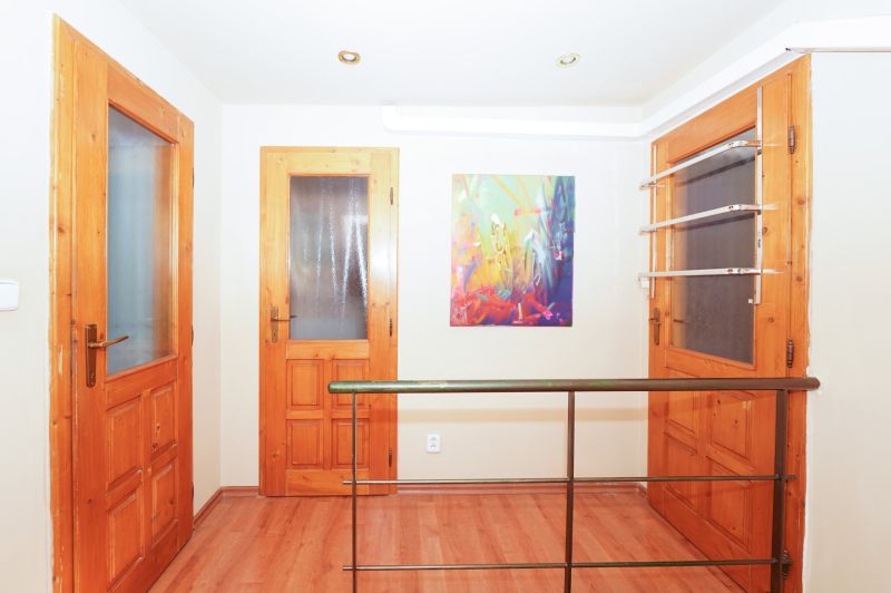 A hallway with wooden doors and a floor with a wooden decor in a family house.