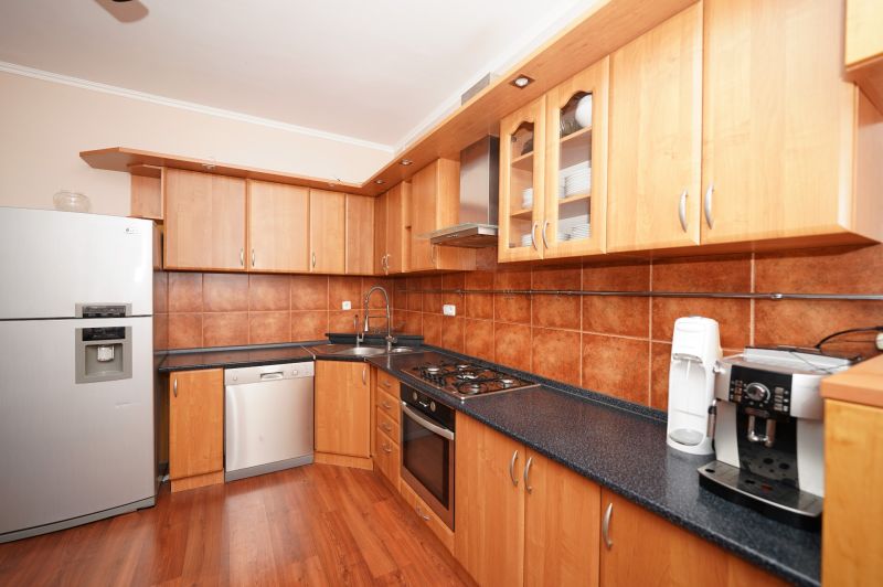 A kitchen in a family house with a wooden floor decor and cooking equipment.