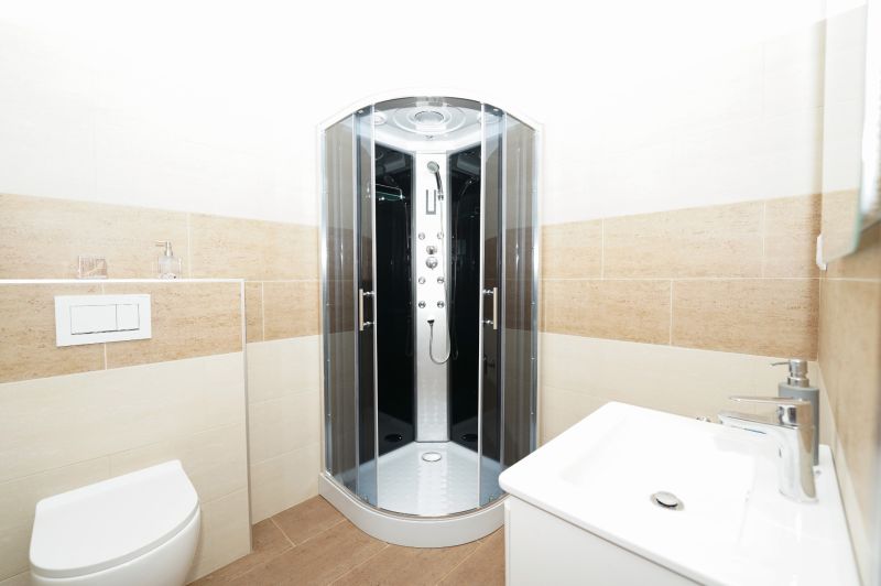 A bathroom with a corner shower and tiles with a light decor in a family house.