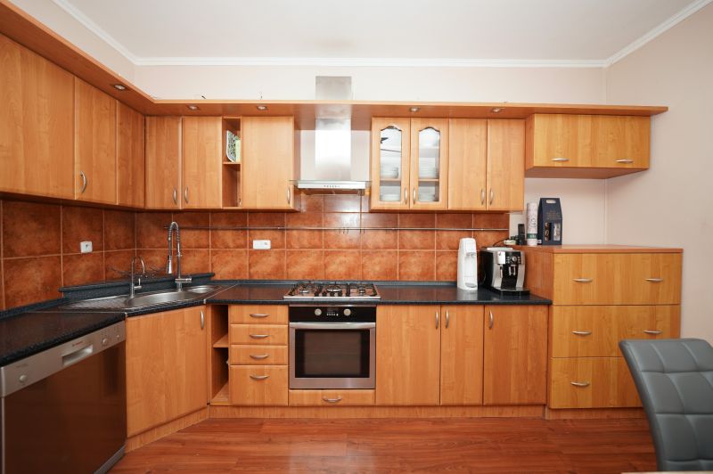 A kitchen in a family house with wooden decor and rustic tiles.