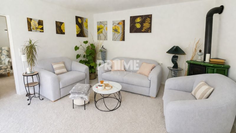 Living room in a family house with armchairs, a fireplace, and art paintings on the wall.